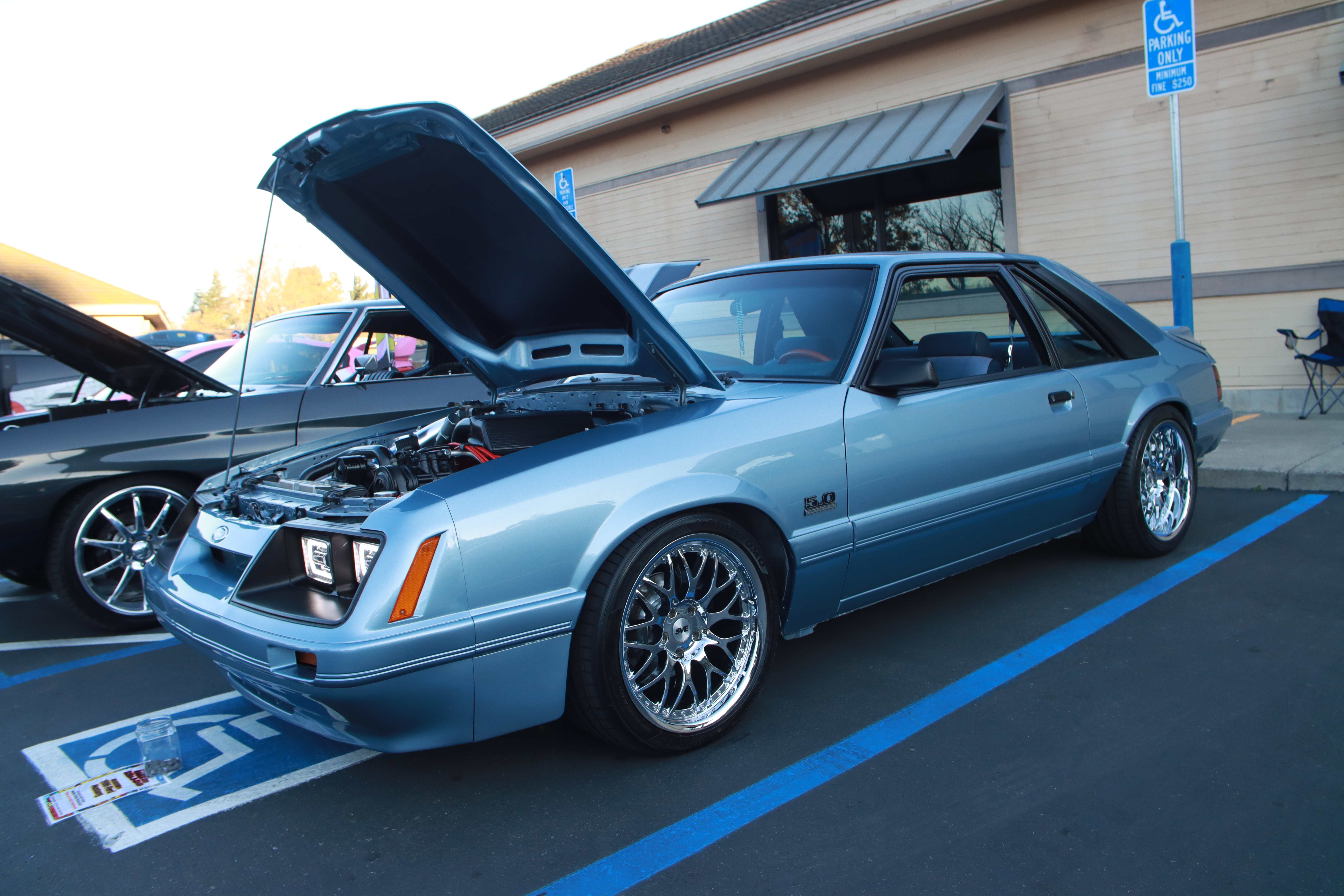 Light blue Fox body Mustang 5.0 with hood open showing engine