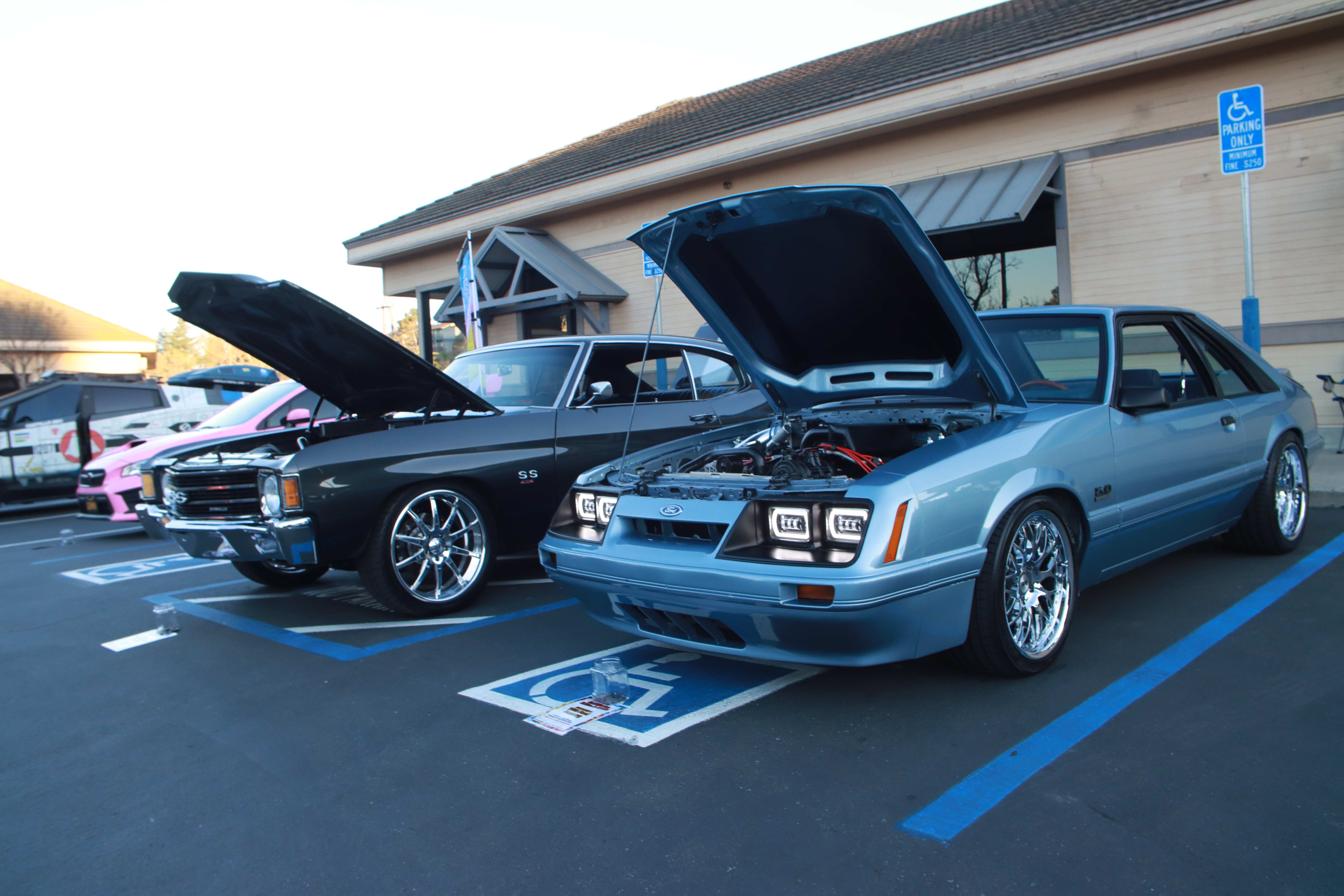 Black Chevelle SS and light blue Mustang with hoods open at Quickly