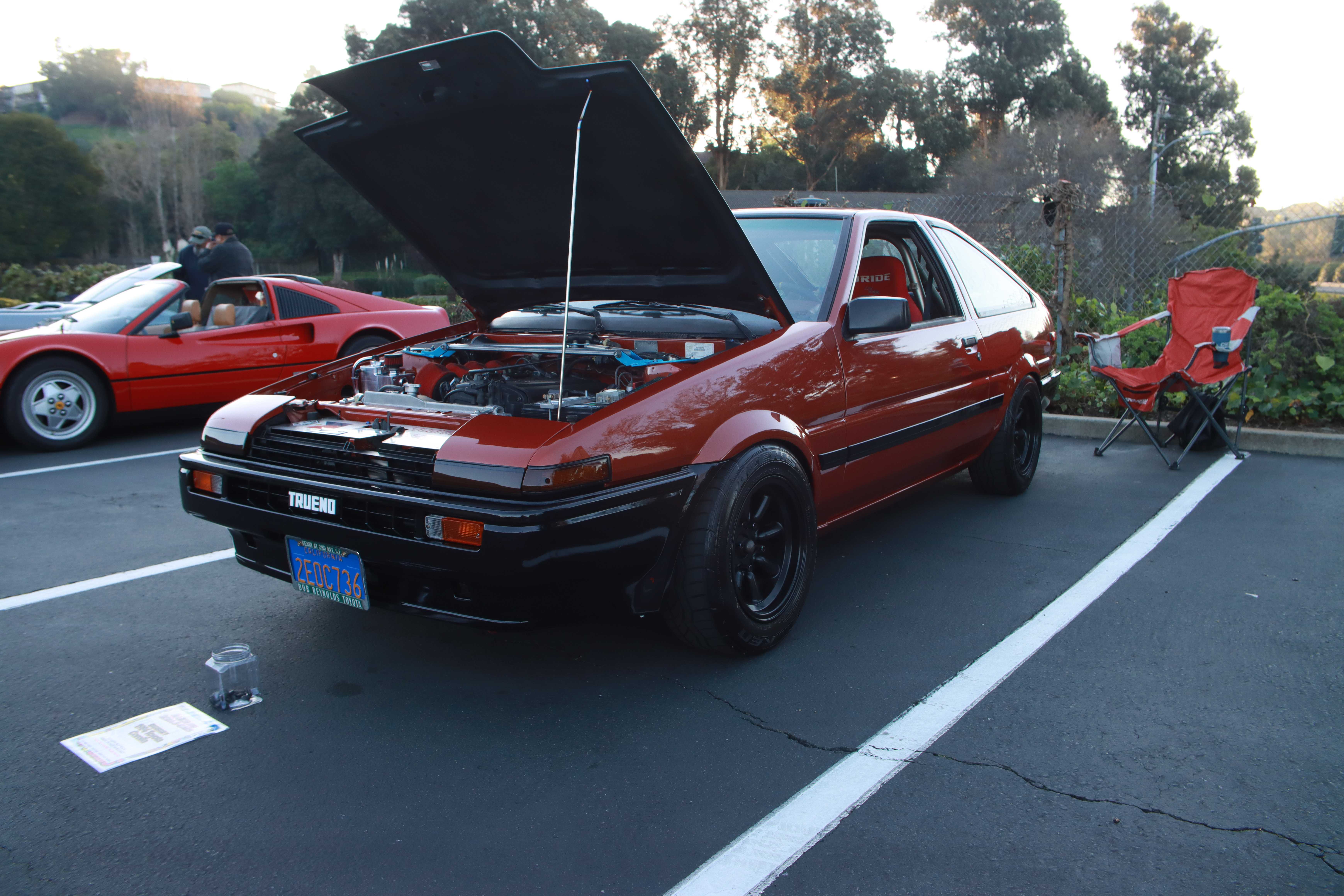 Red Toyota AE86 Corolla Trueno with hood open showing turbocharged engine