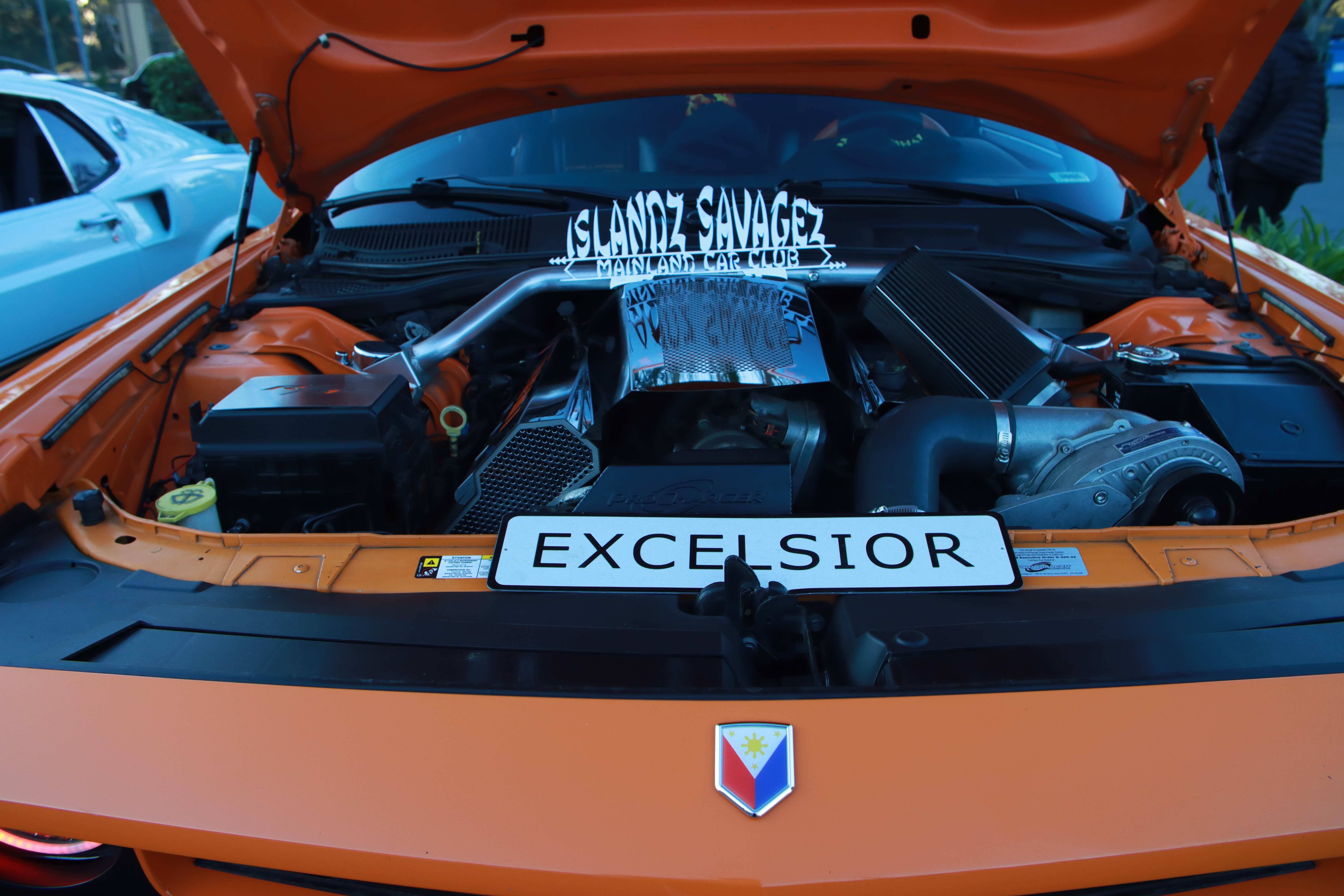 Orange Oldsmobile Cutlass engine bay showing supercharged motor and Excelsior radiator support