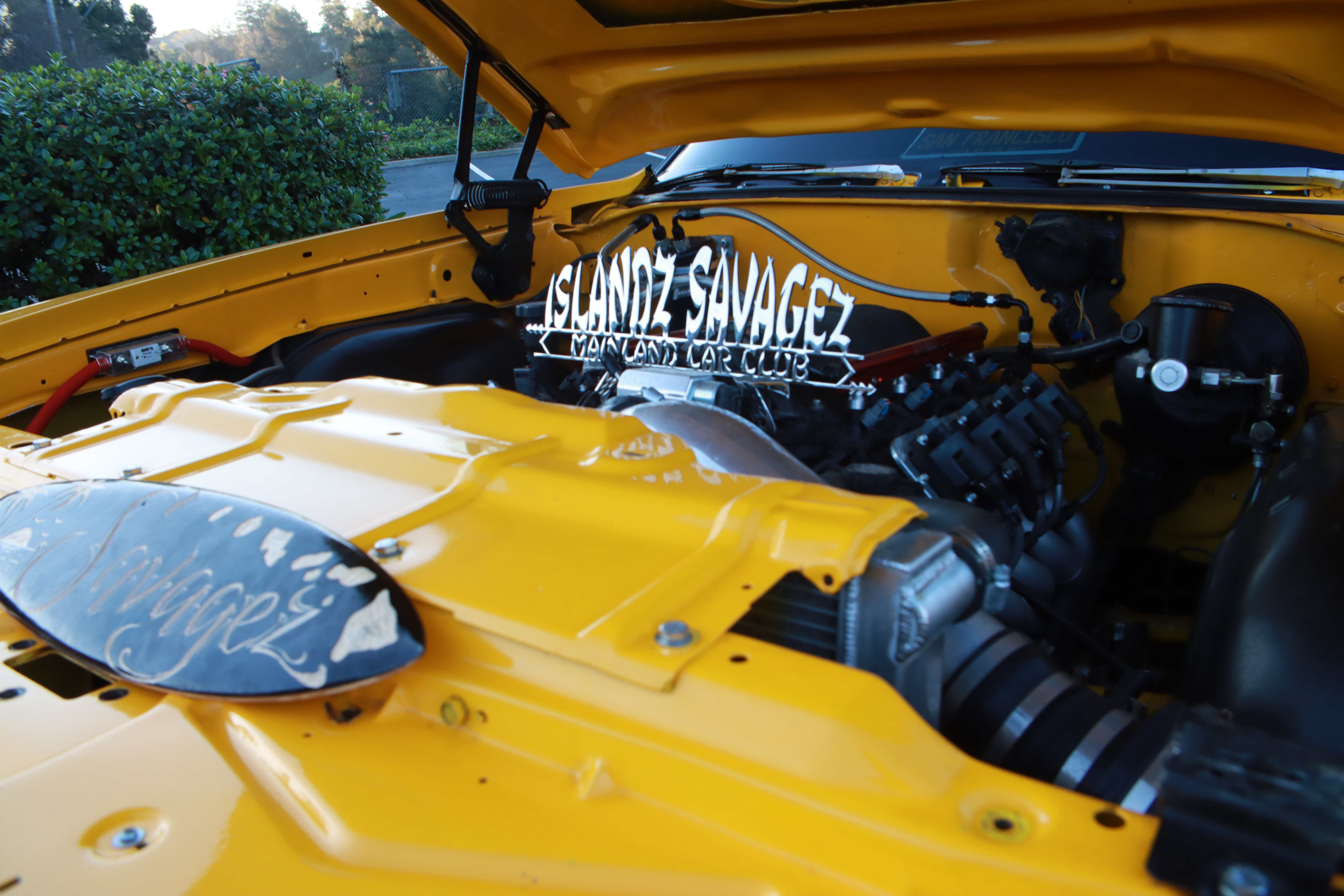 Yellow Oldsmobile Cutlass custom interior with white steering wheel and black leather seats